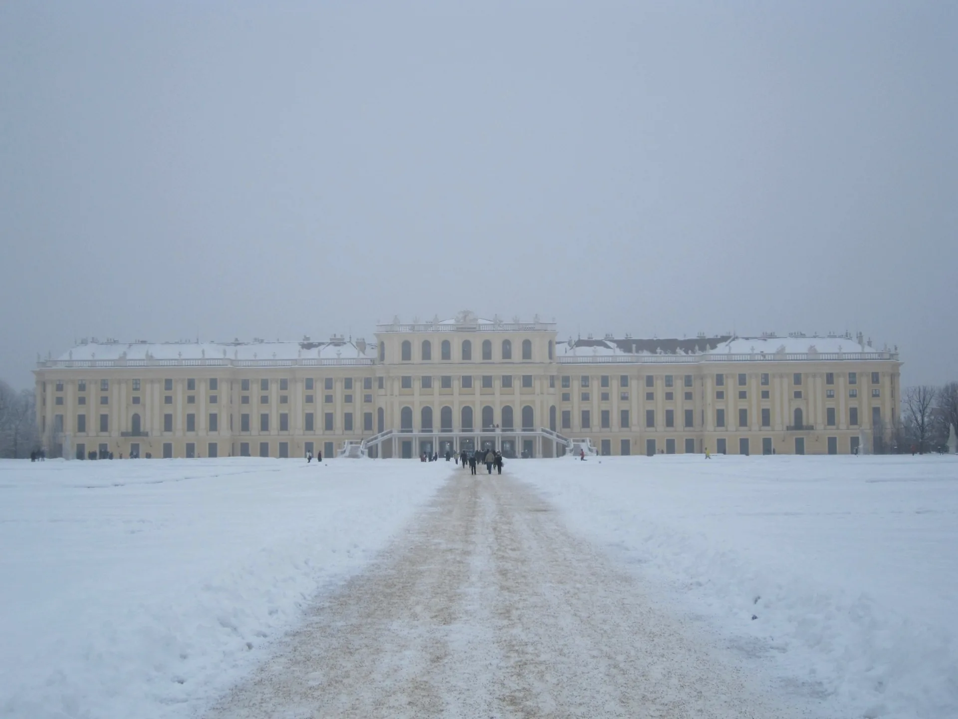 Schönbrunn Palace viewed across the snow-covered Great Parterre in winter.
