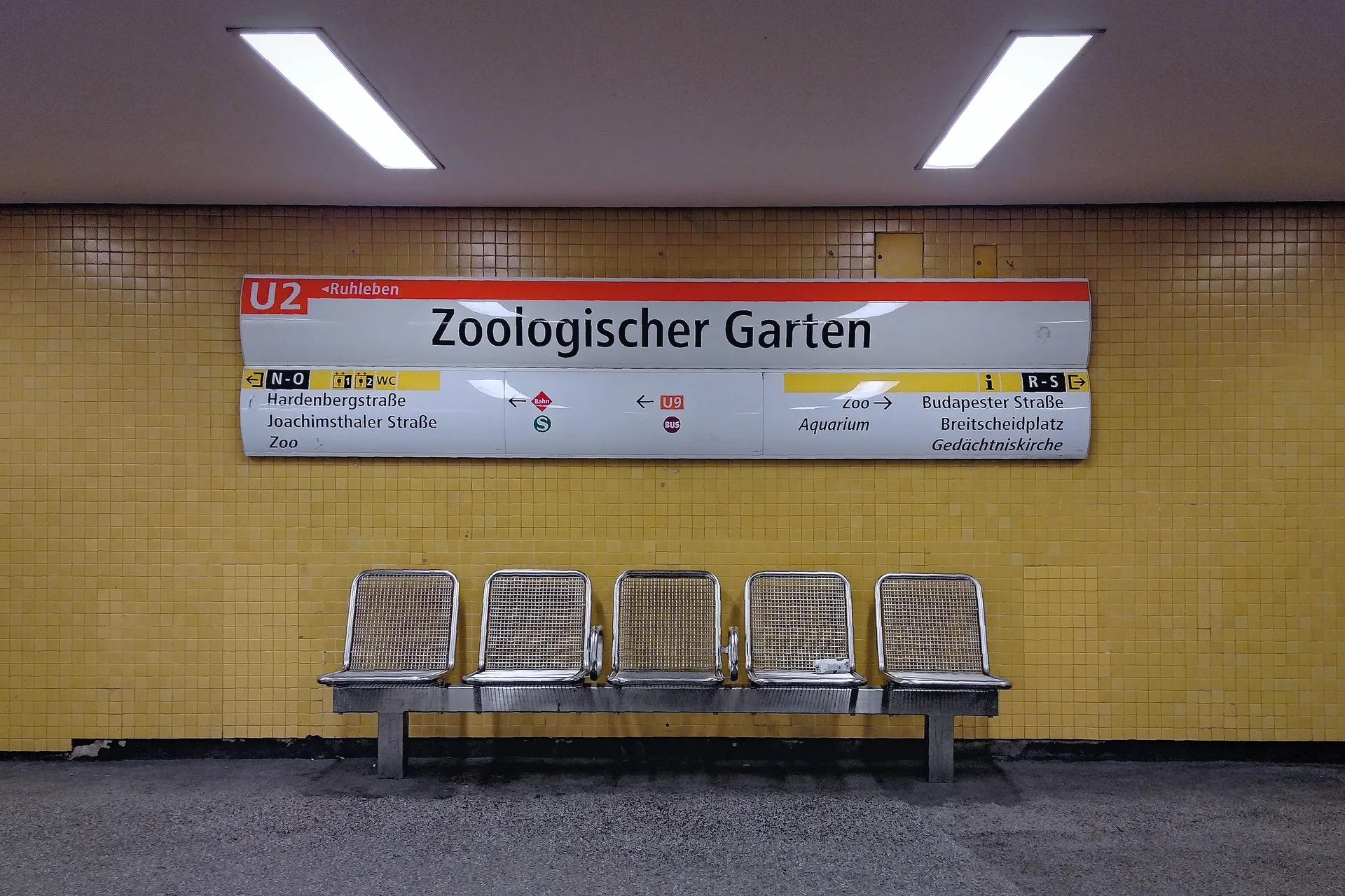 The platform at Zoologischer Garten U-Bahn station, with a train track and tiled wall.