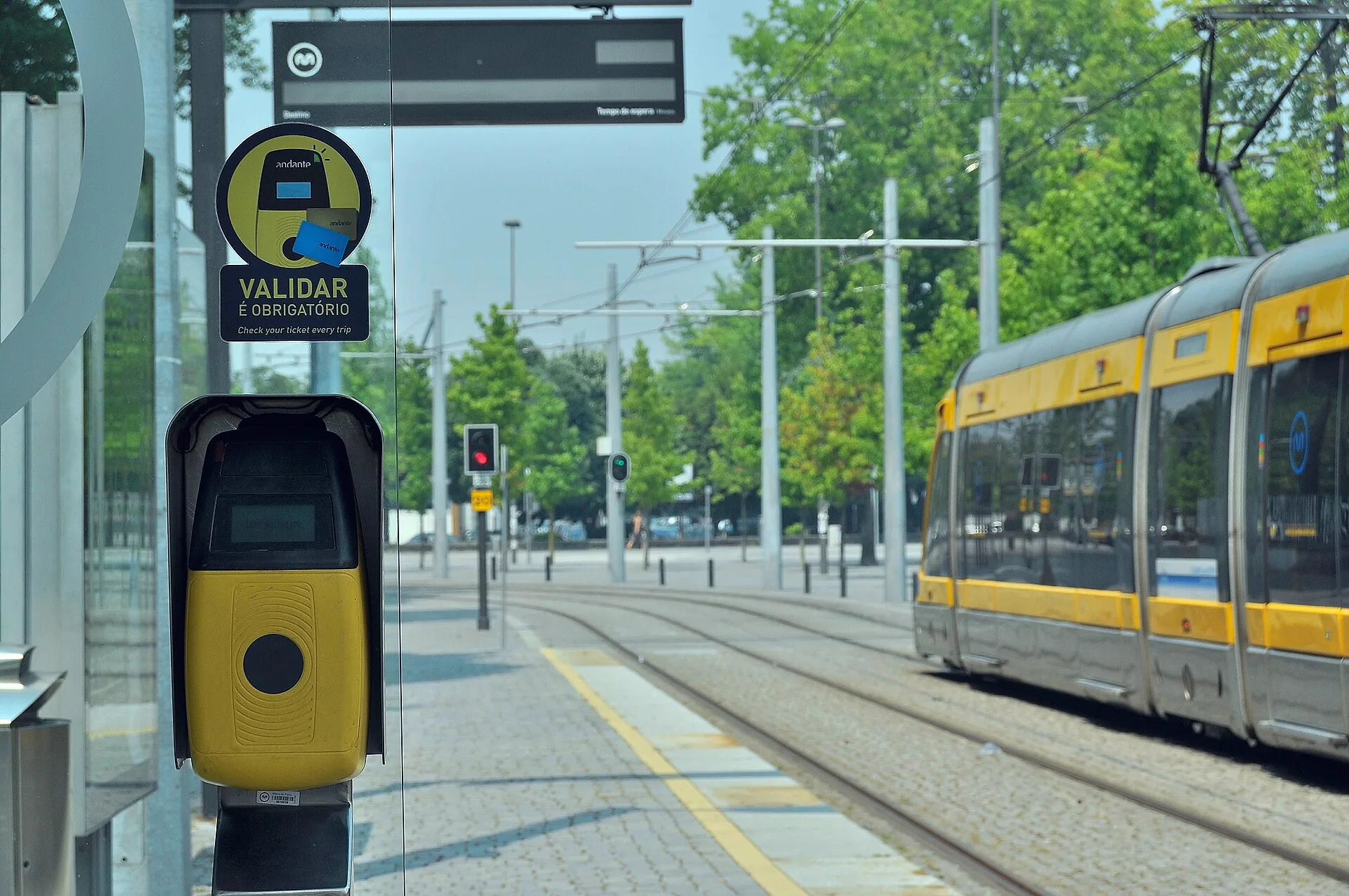 A Metro do Porto tram stopped at Hospital de São João, with an Andante ticket validator visible beside the platform.