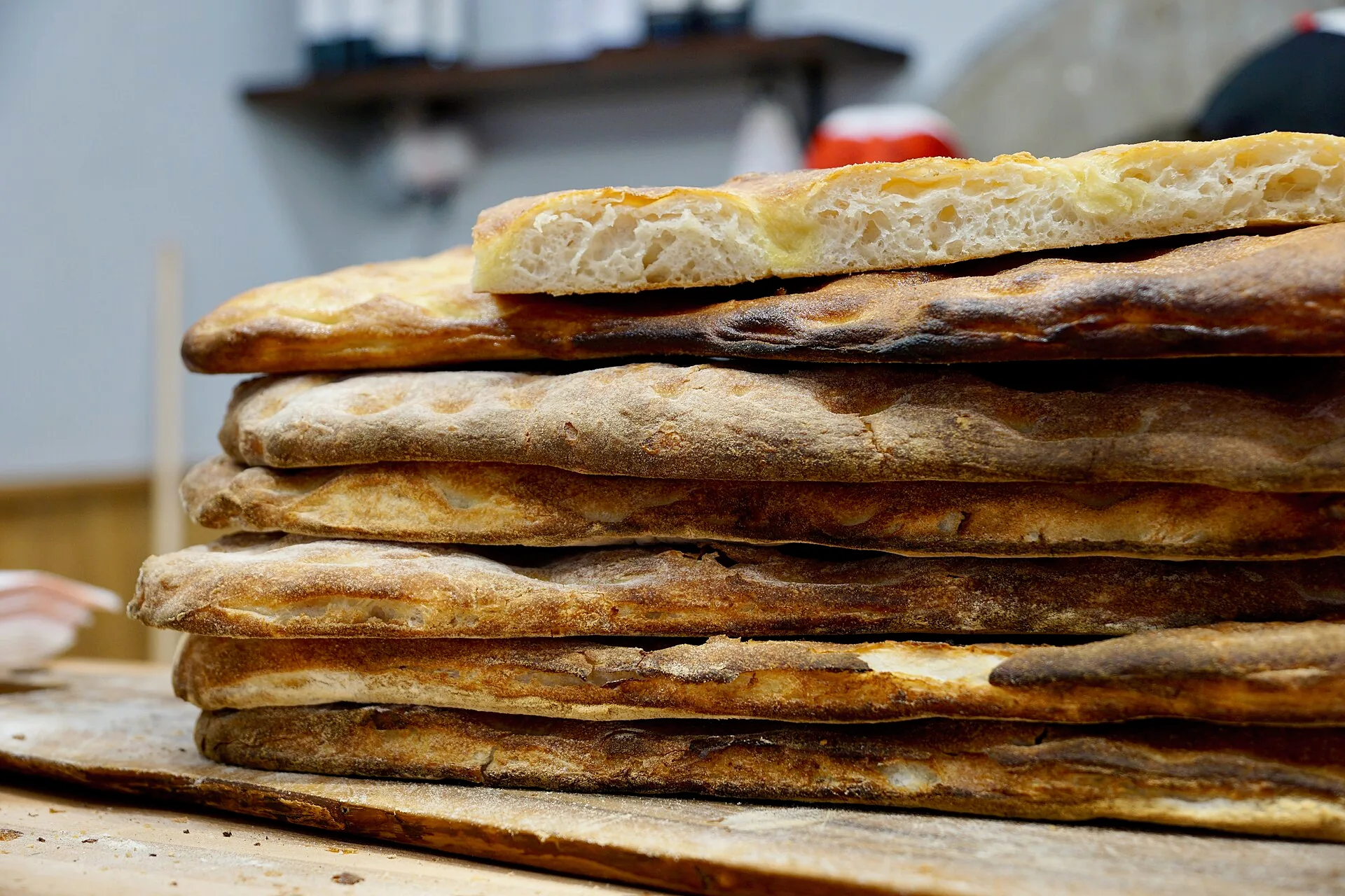 Slices of schiacciata alla fiorentina stacked in a bakery.
