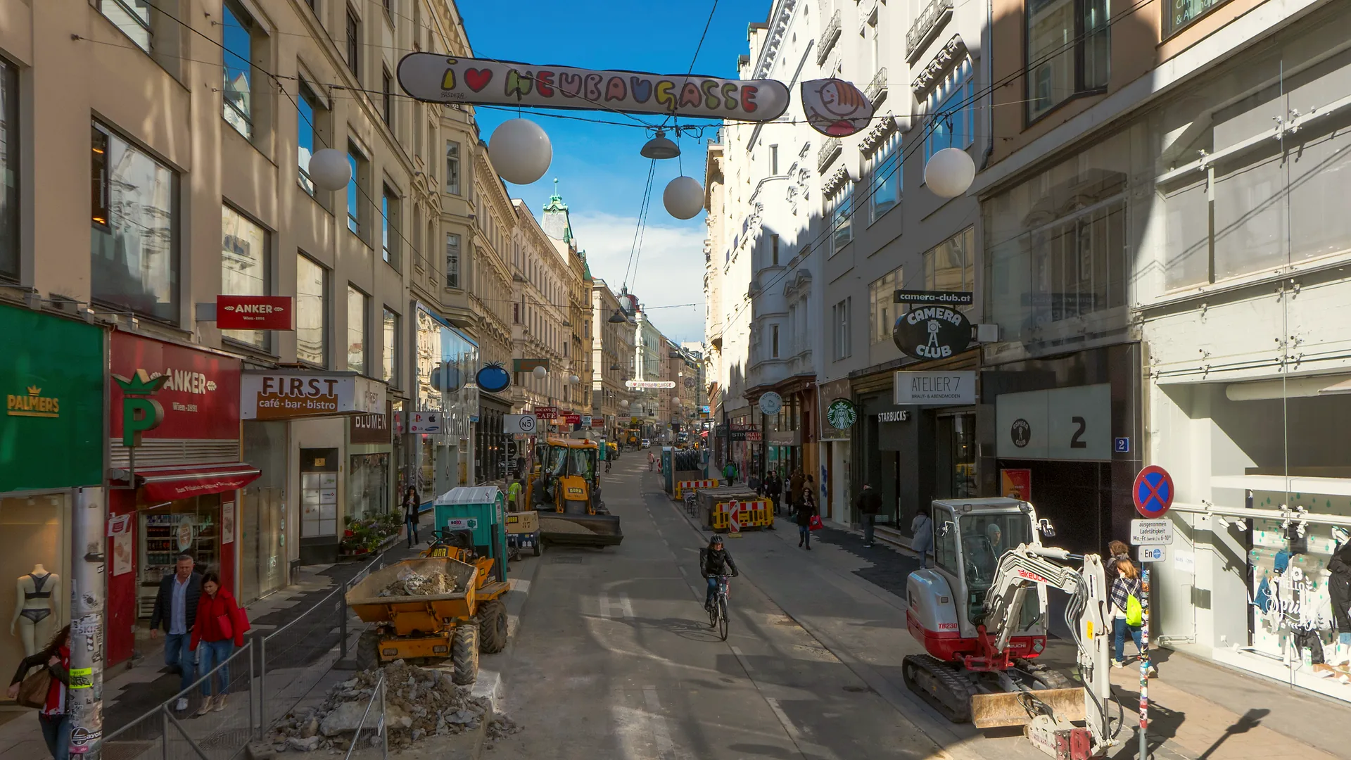 Neubaugasse running north from Mariahilfer Straße, with buildings and shops along the street.