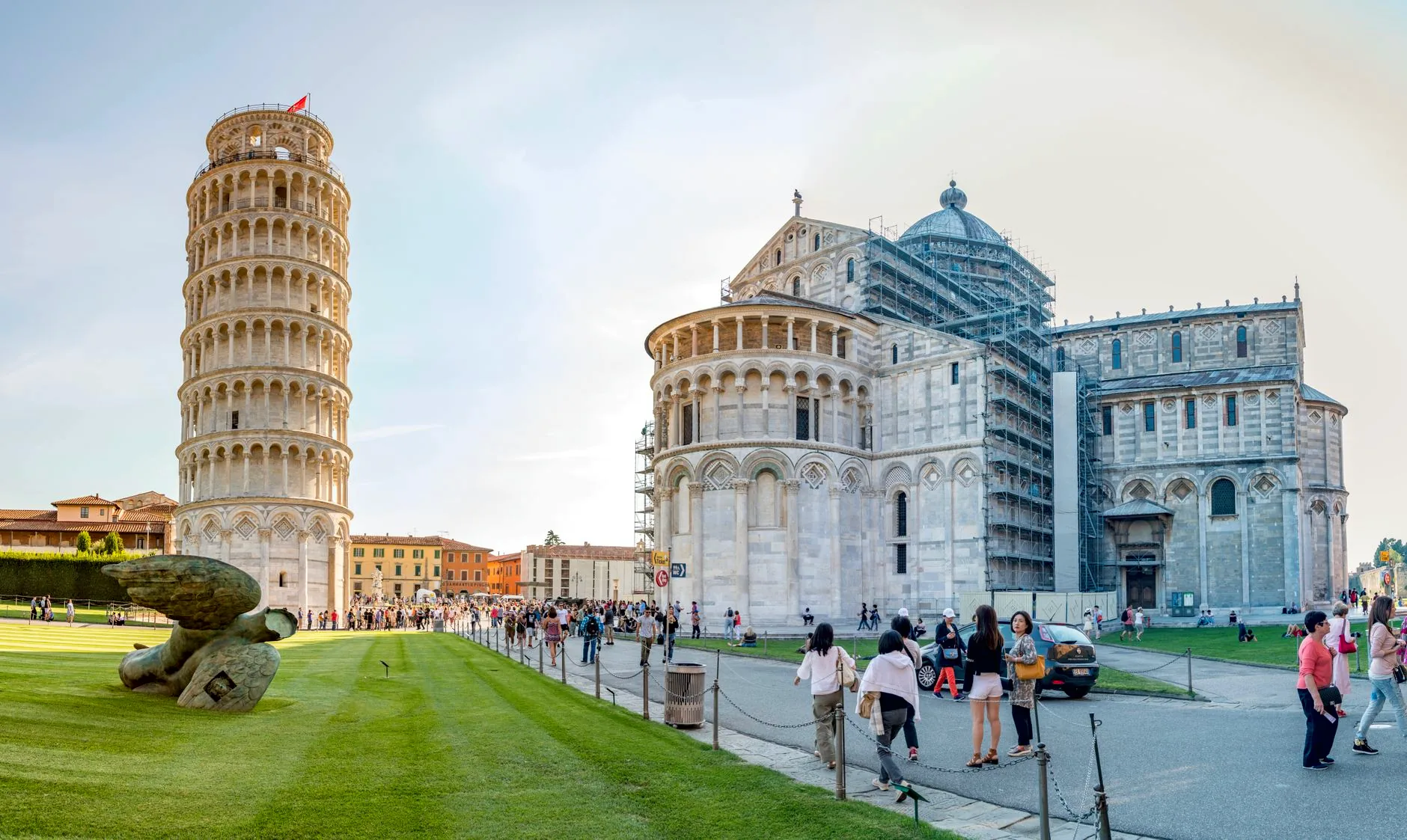 The Leaning Tower of Pisa and Pisa Cathedral rise above visitors in Piazza del Duomo.