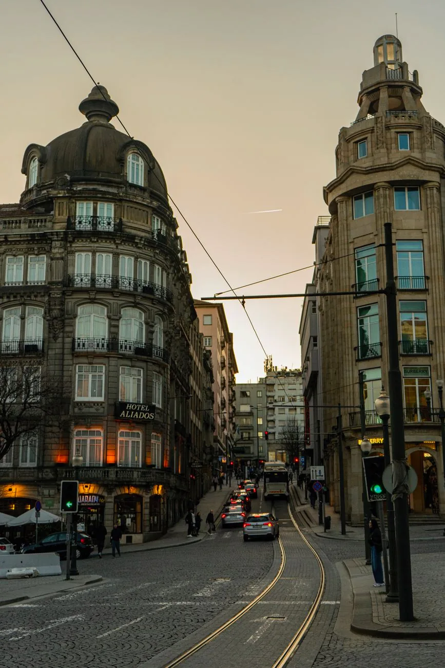 Historic buildings line Avenida dos Aliados at dusk in Porto.