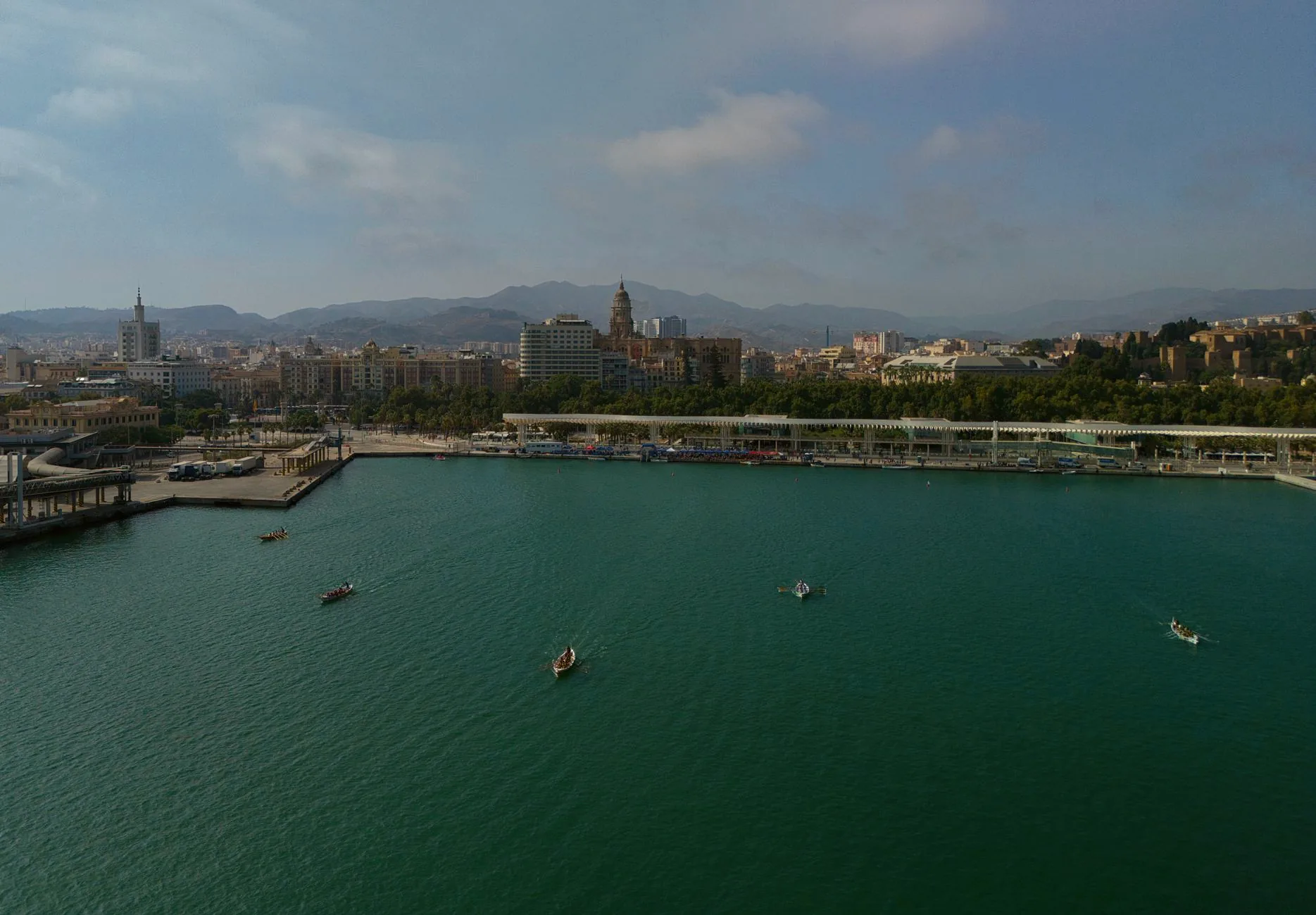 Aerial view across Málaga’s harbour, with boats in the bay and historic buildings along the waterfront.