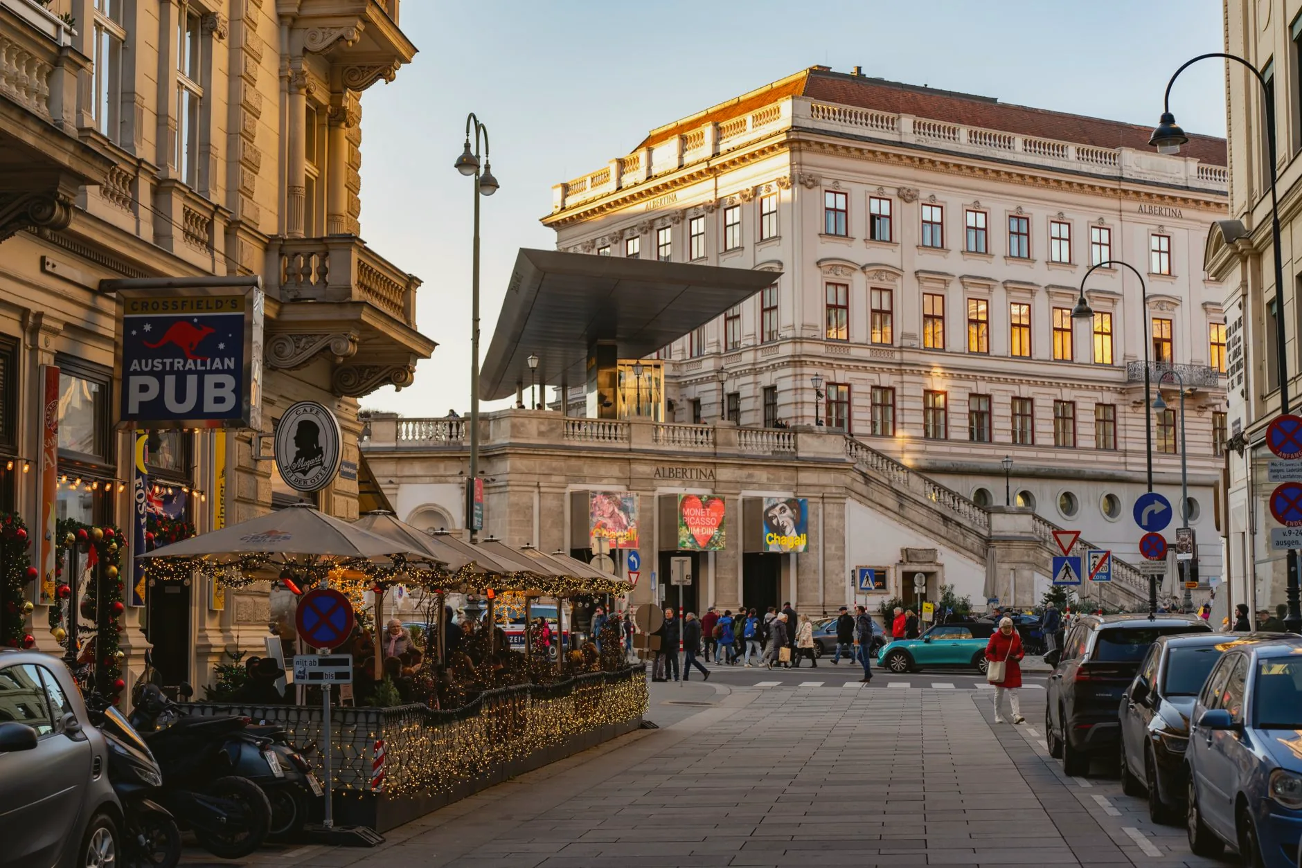 Vienna street beside the Albertina Museum, with people gathered outside a pub.