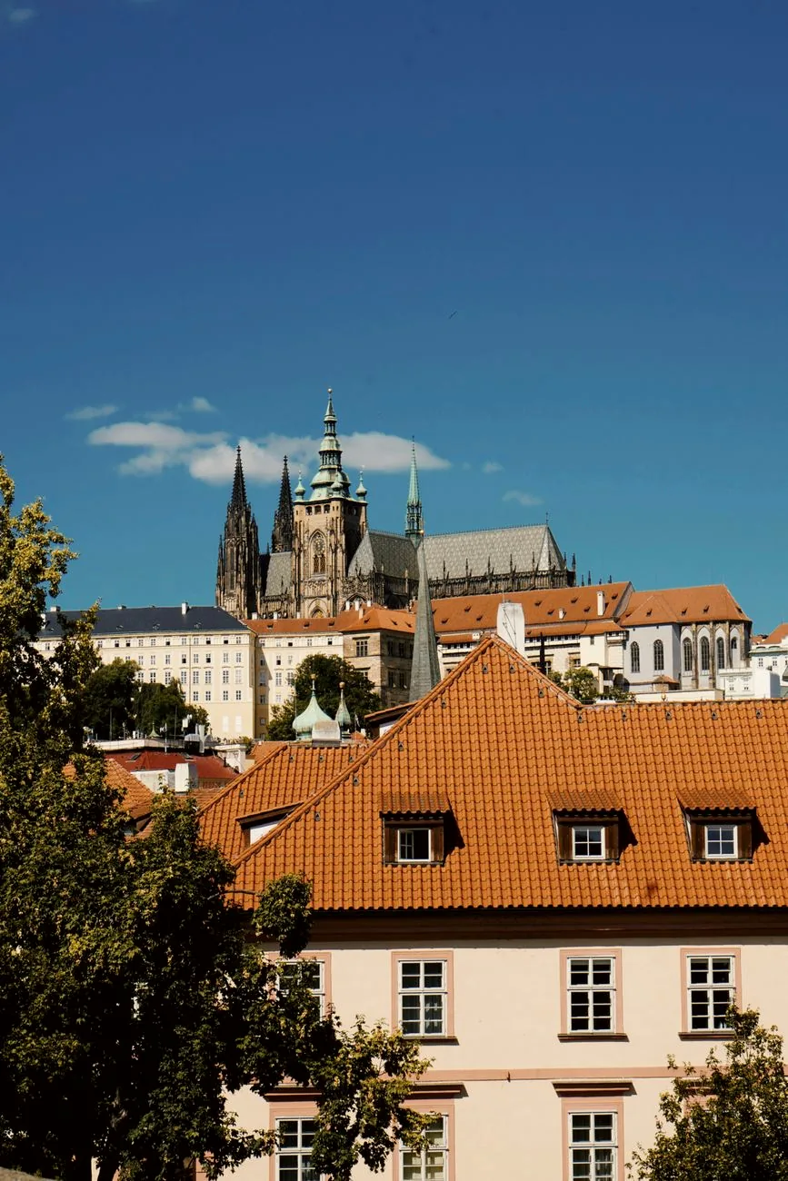 Prague Castle and historic buildings beneath a blue sky.