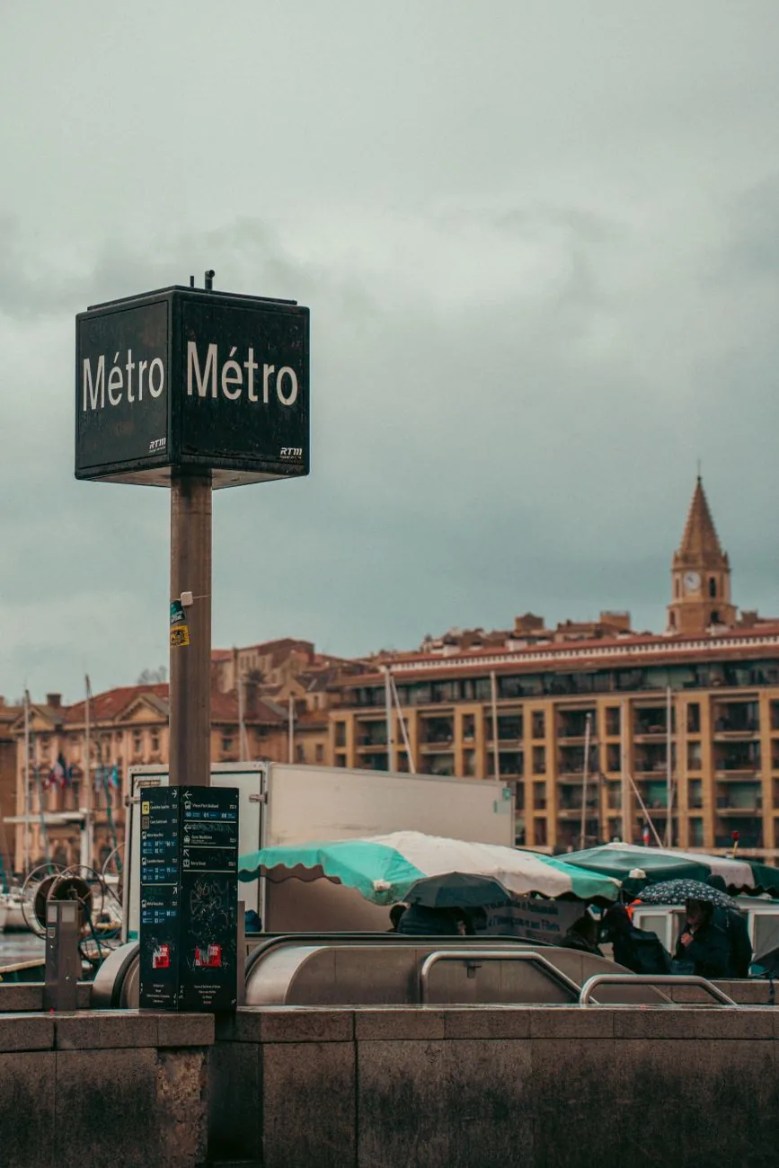 Metro sign at Vieux-Port in Marseille, with historic buildings behind