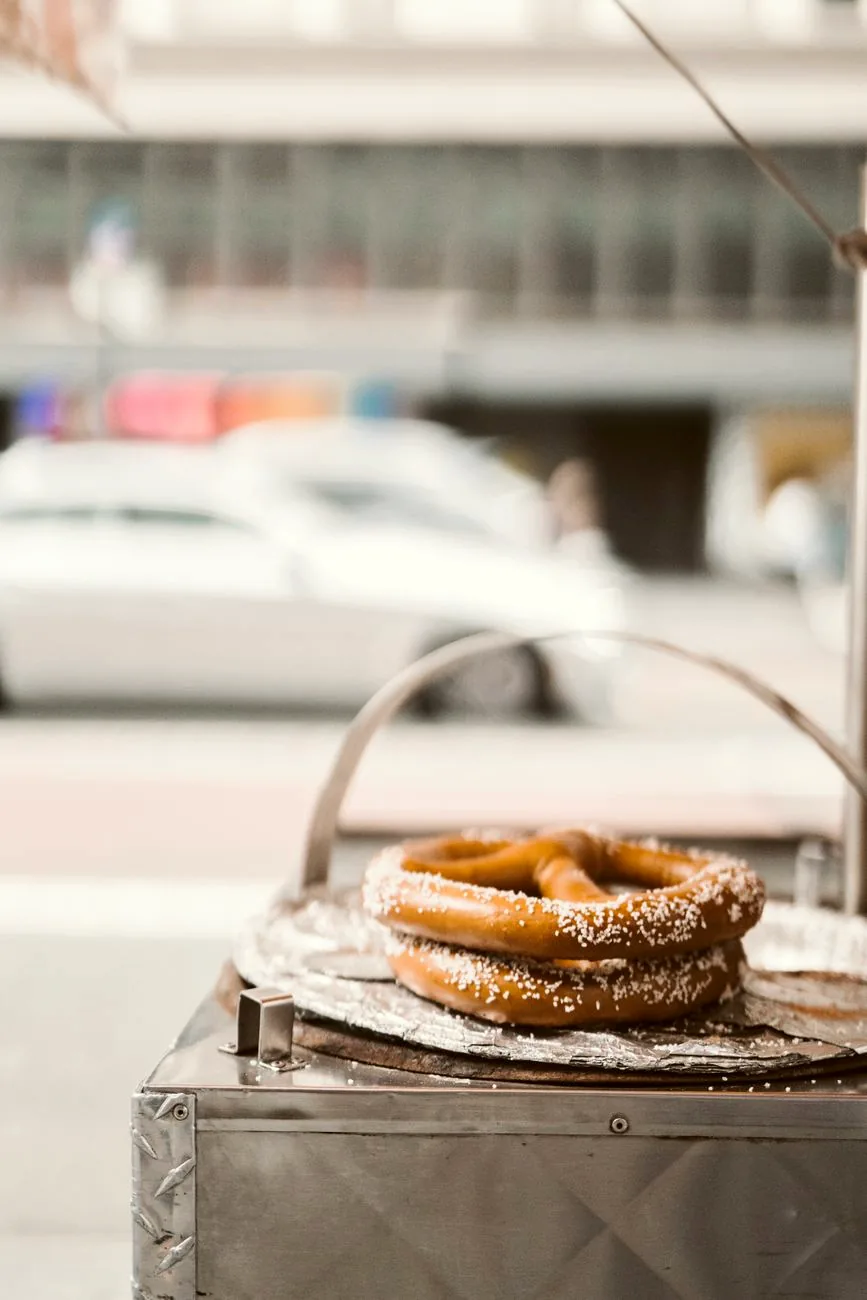 Salted pretzels displayed on a street food cart.