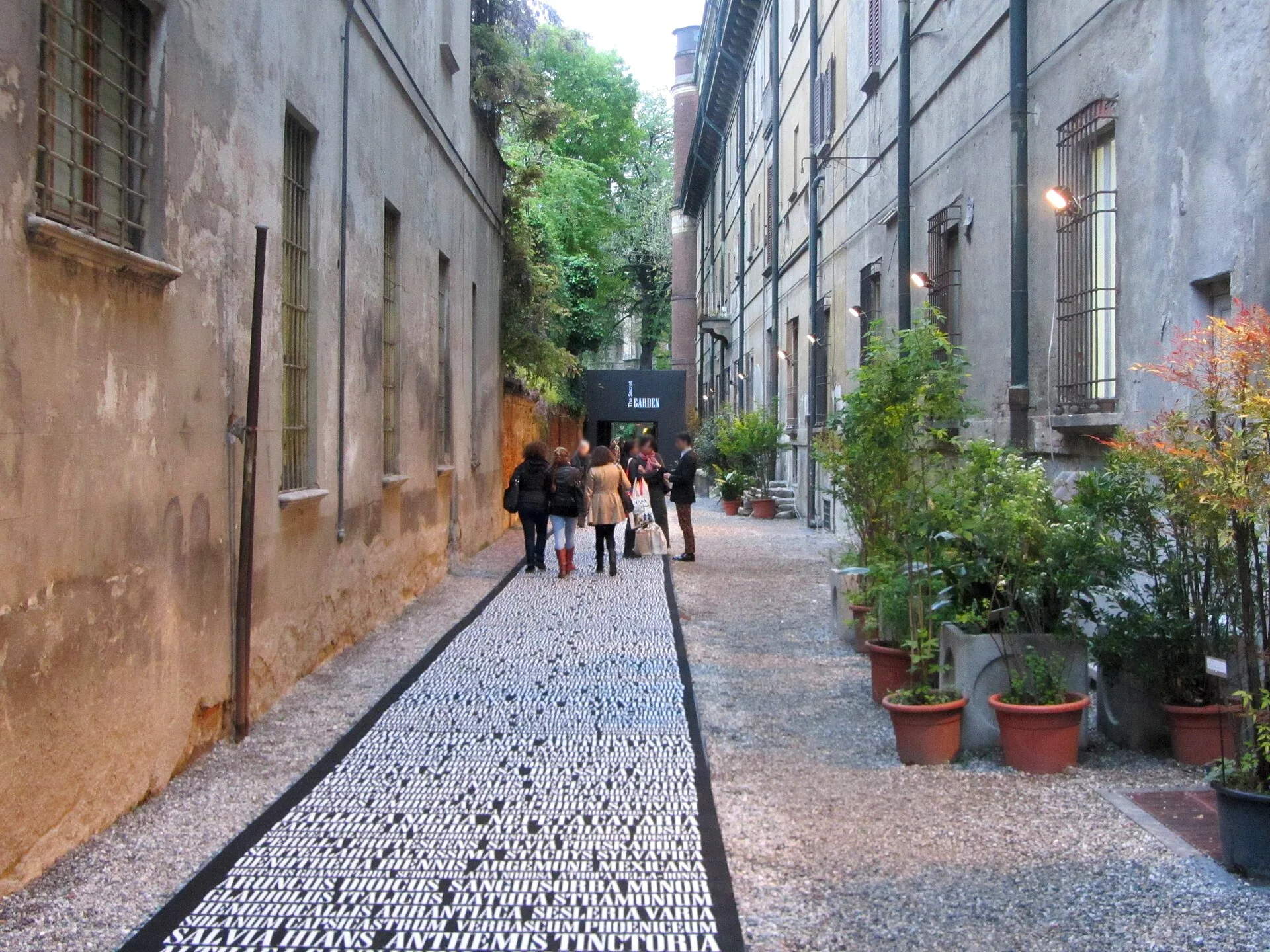 A garden installation at the Brera Botanical Garden during Milan Design Week, with sculptural furnishings among the plants.