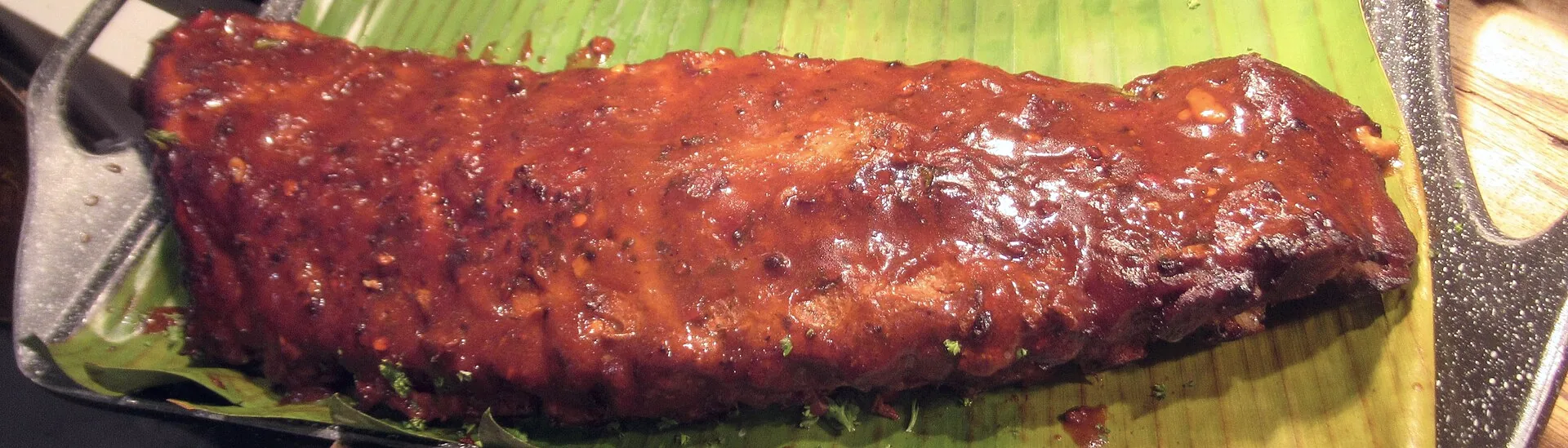 Barbecued pork ribs coated in sauce.