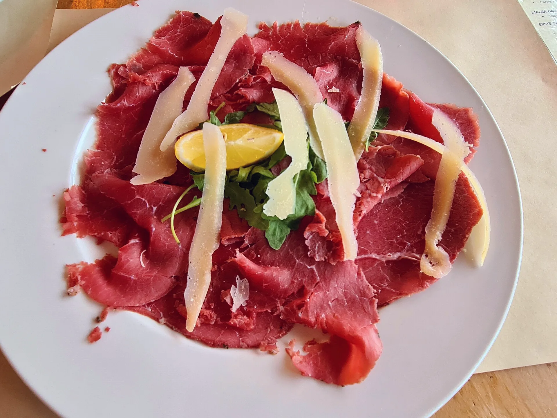 Slices of carne salada topped with Trentingrana cheese.