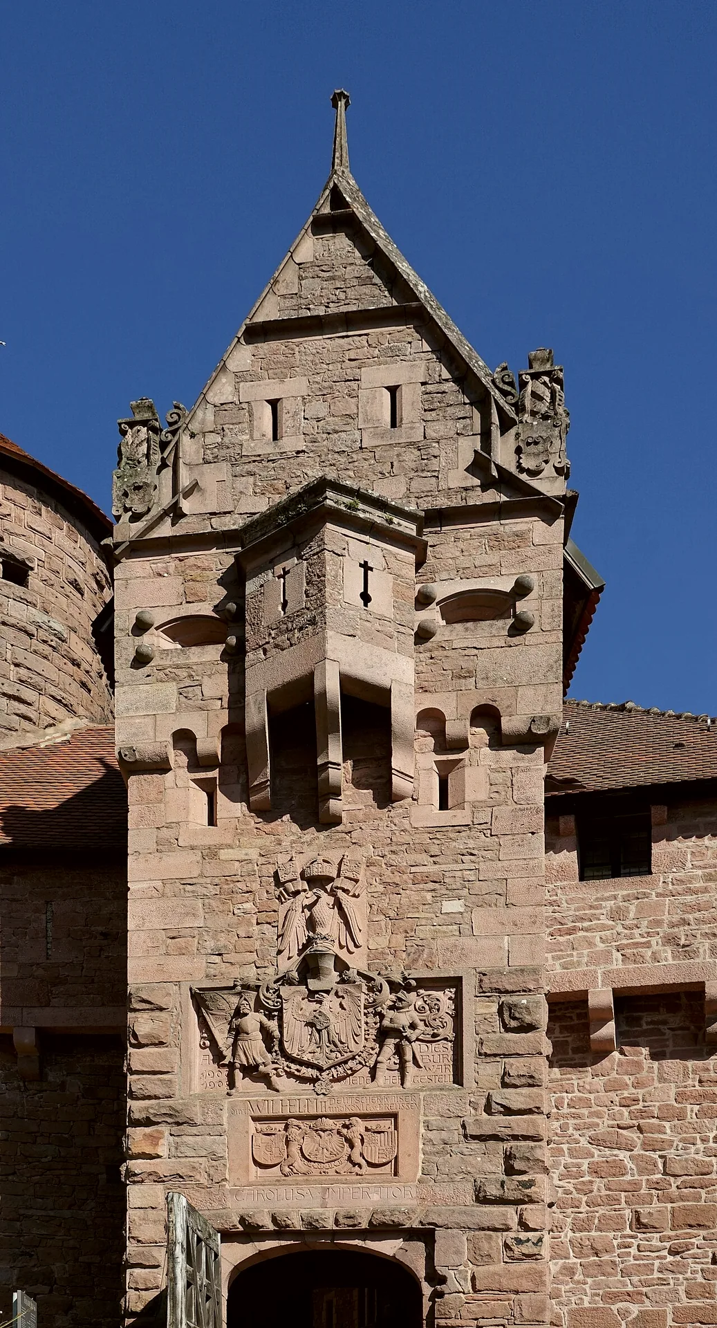 The entrance to Château du Haut-Koenigsbourg, with its stone walls and tower.