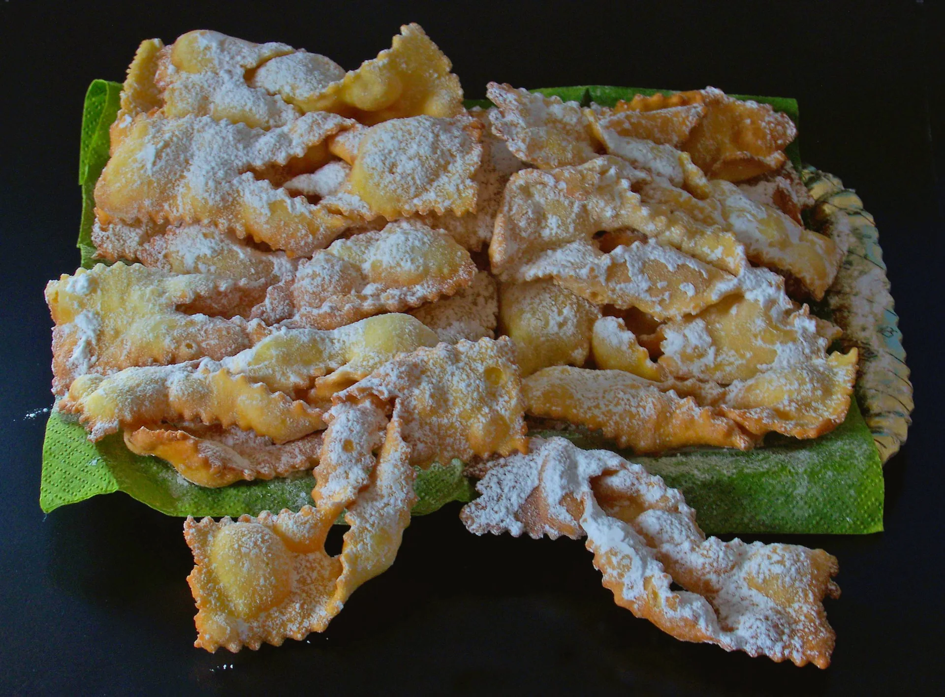 Thin, folded carnival pastries covered with powdered sugar.