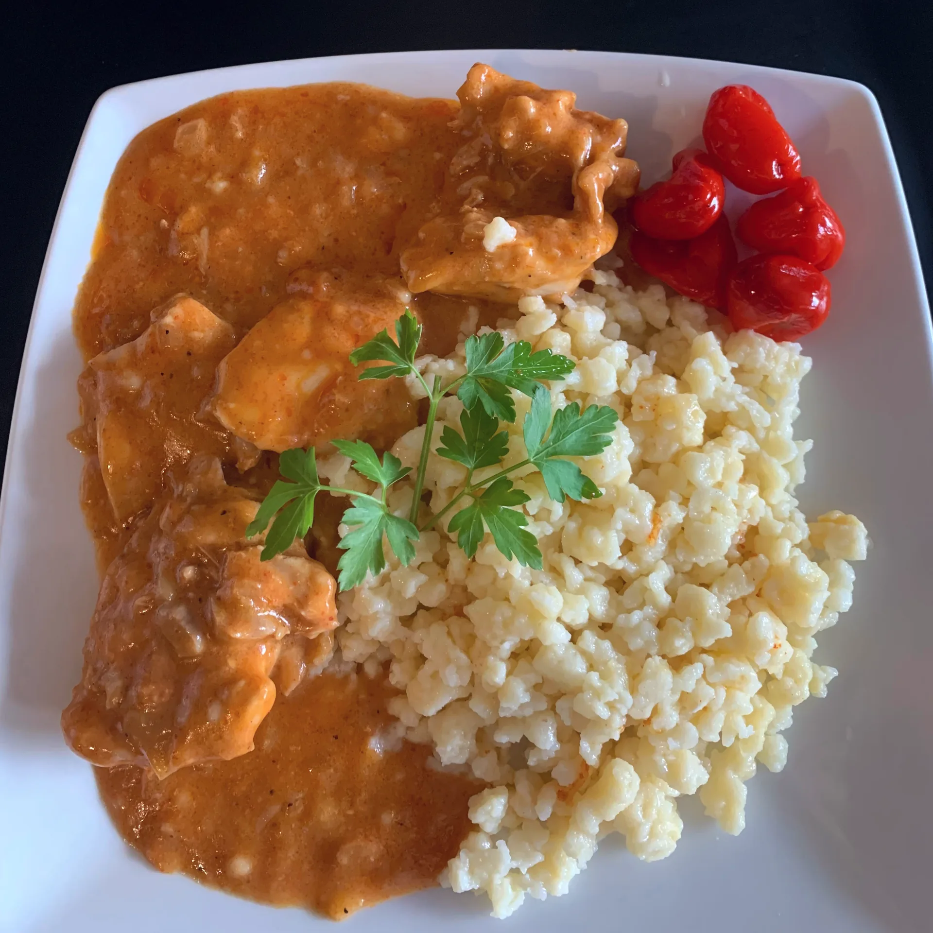 A serving of chicken paprikash, a Hungarian dish of chicken in a paprika-rich sauce.