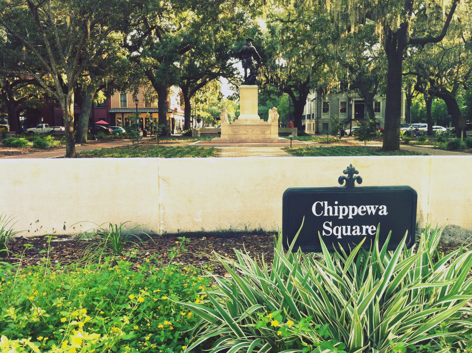 View across Chippewa Square in Savannah from Hull Street, with trees and the surrounding buildings.
