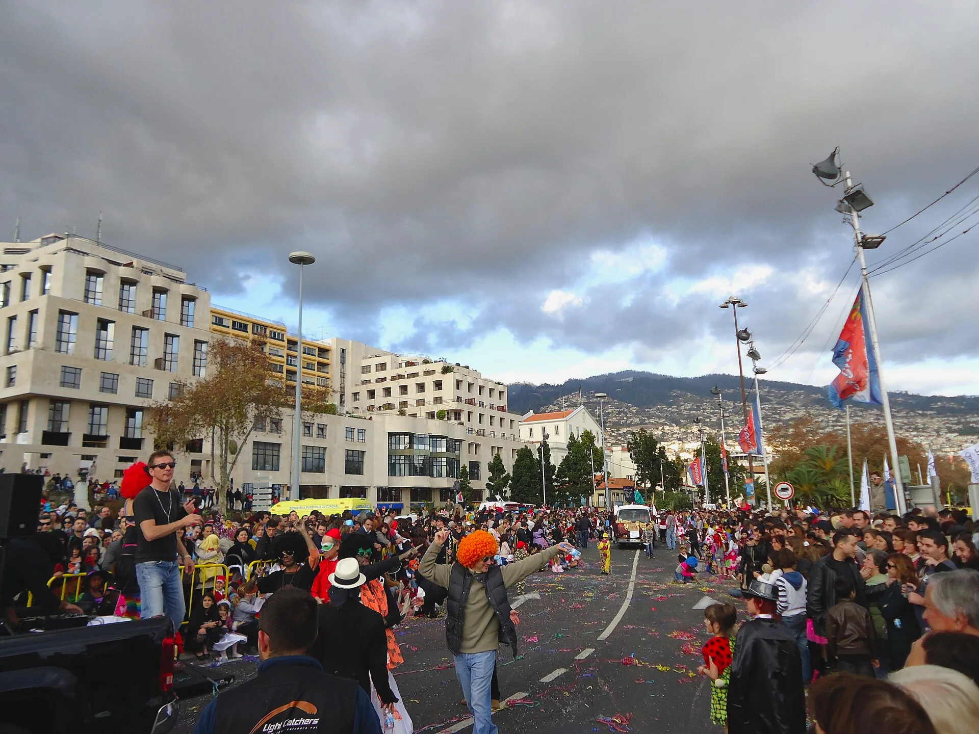 A crowd in costume taking part in the Cortejo Trapalhão parade in Funchal.