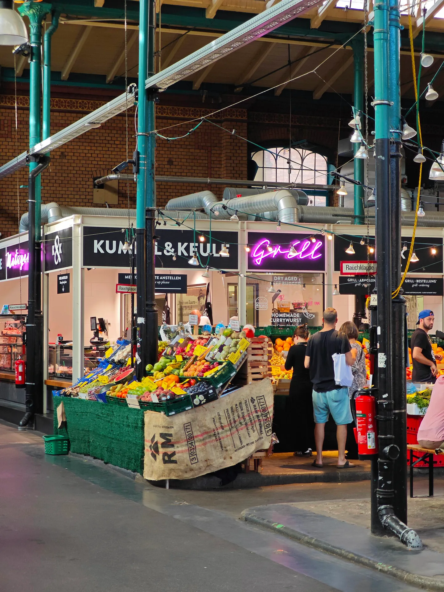 Interior of Markthalle Neun, with its market hall roof and stalls.