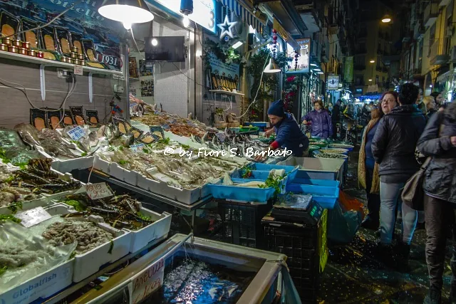Stalls at the Pignasecca market in Naples, crowded with produce and goods for Christmas Eve.