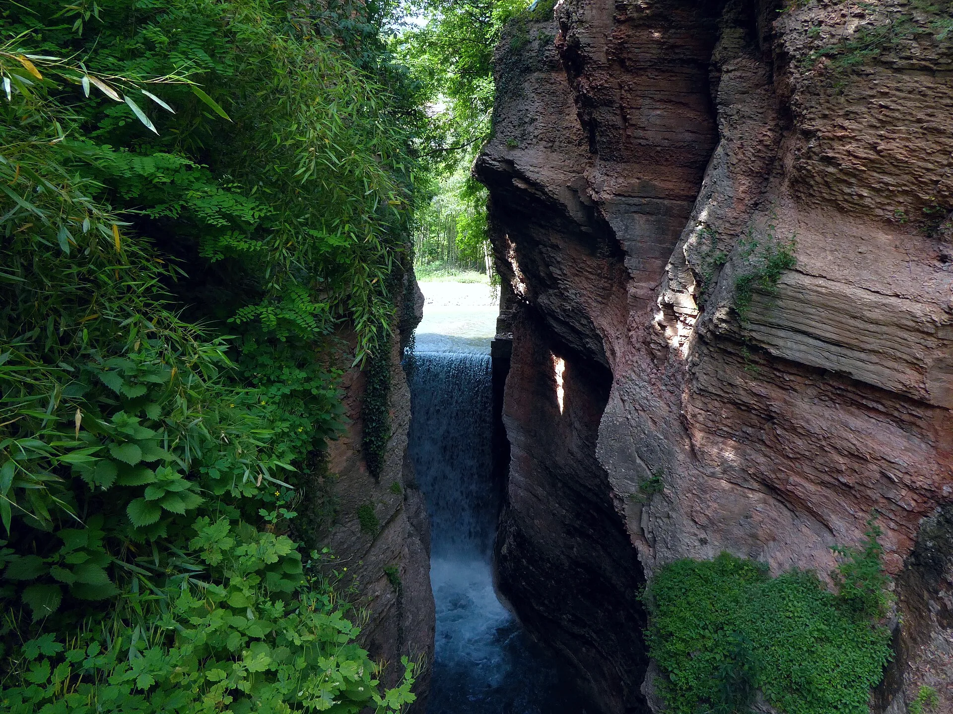 The Ponte Alto ravine in Trento, with water cutting through a rocky gorge.