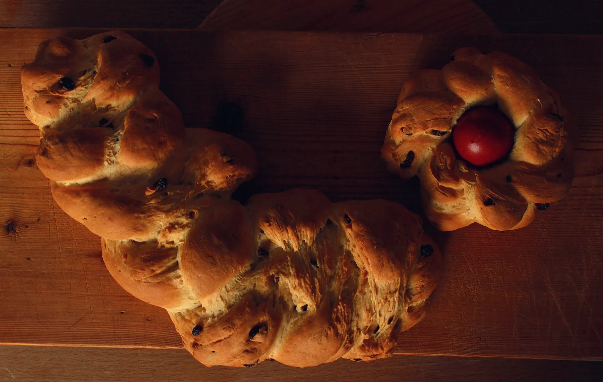 A braided sweet yeast Easter bread beside a nest-shaped Easter bread.
