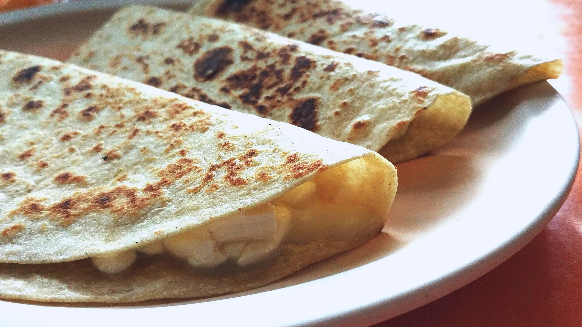A quesadilla made with a folded tortilla and melted cheese.