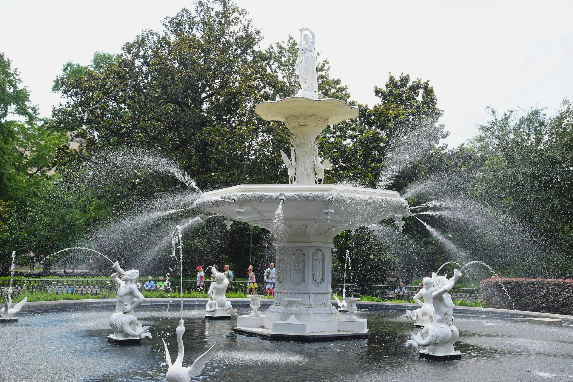 The tiered Forsyth Park fountain stands in its circular pool, with water spouting from the basin.