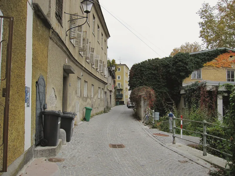 The narrow Steingasse, with buildings set below the hillside cliff.