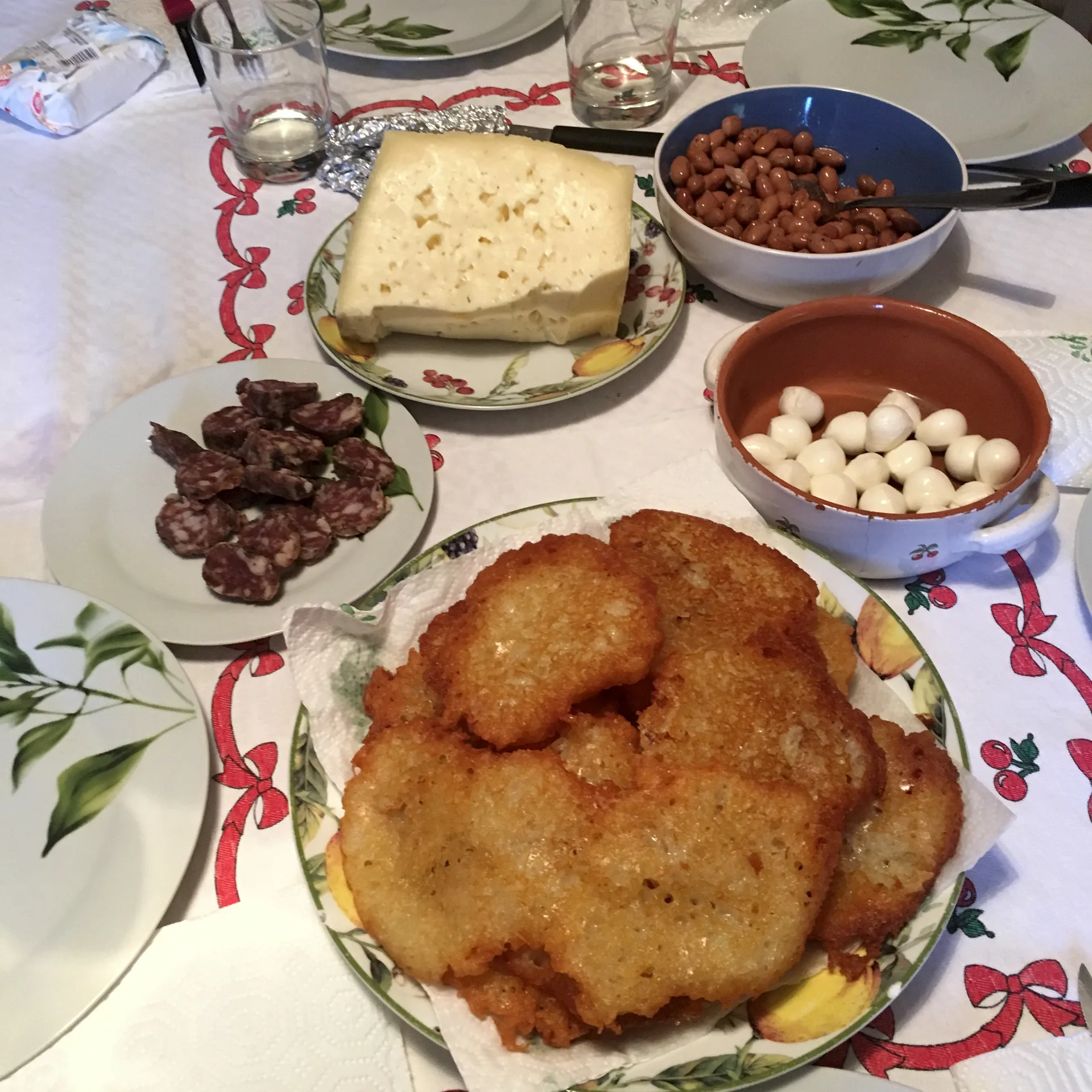A plate of tortei di patate served with greens, cured meats and cheeses.