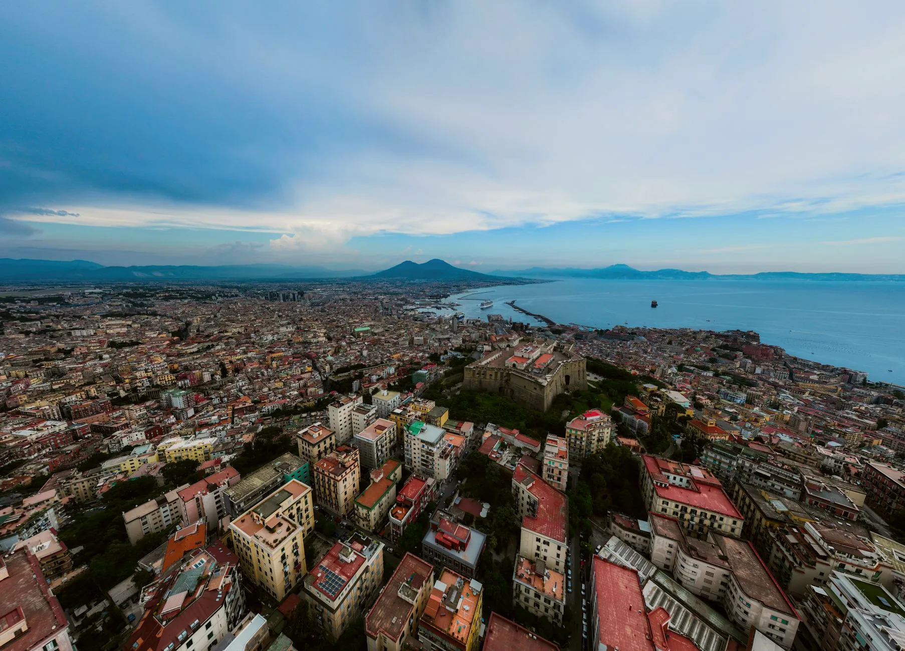 Panoramic aerial view of Naples, with Mount Vesuvius beside the Mediterranean Sea.