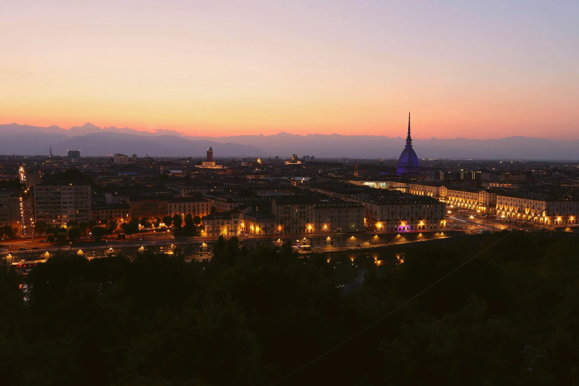 Turin skyline at twilight, with the Mole Antonelliana rising above the surrounding buildings.
