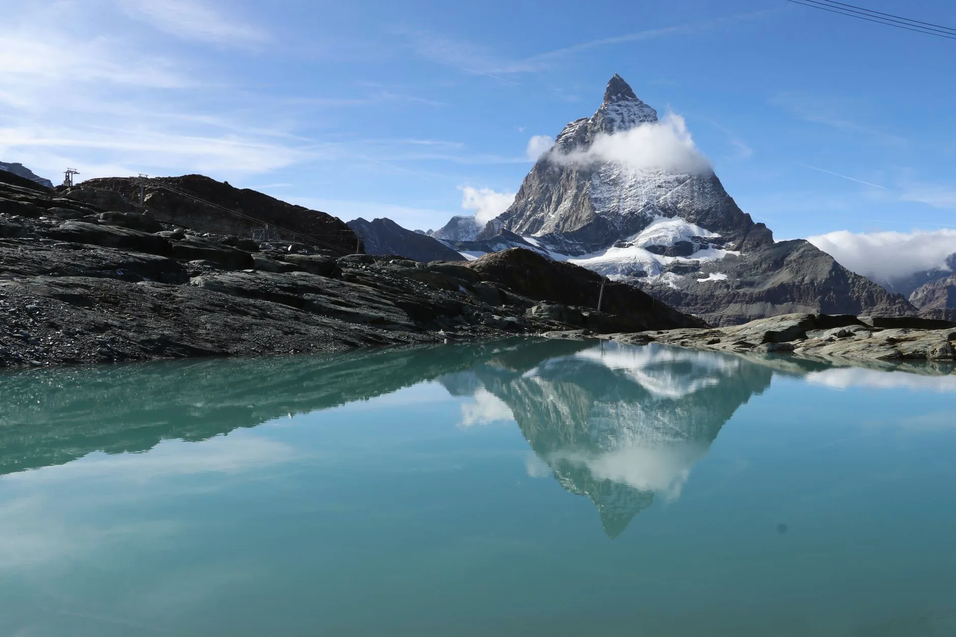 The Matterhorn reflected in an alpine lake beneath a clear blue sky.