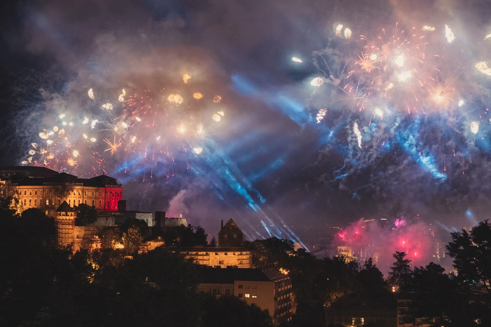 Fireworks burst above Buda Castle in Budapest at night.