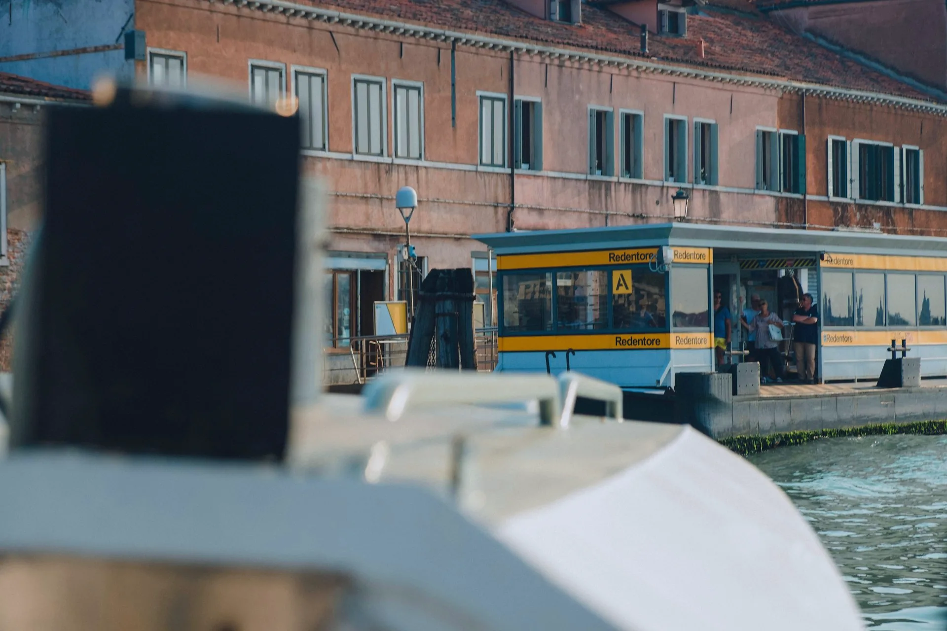 Passengers aboard a Venice water bus travelling along a canal.