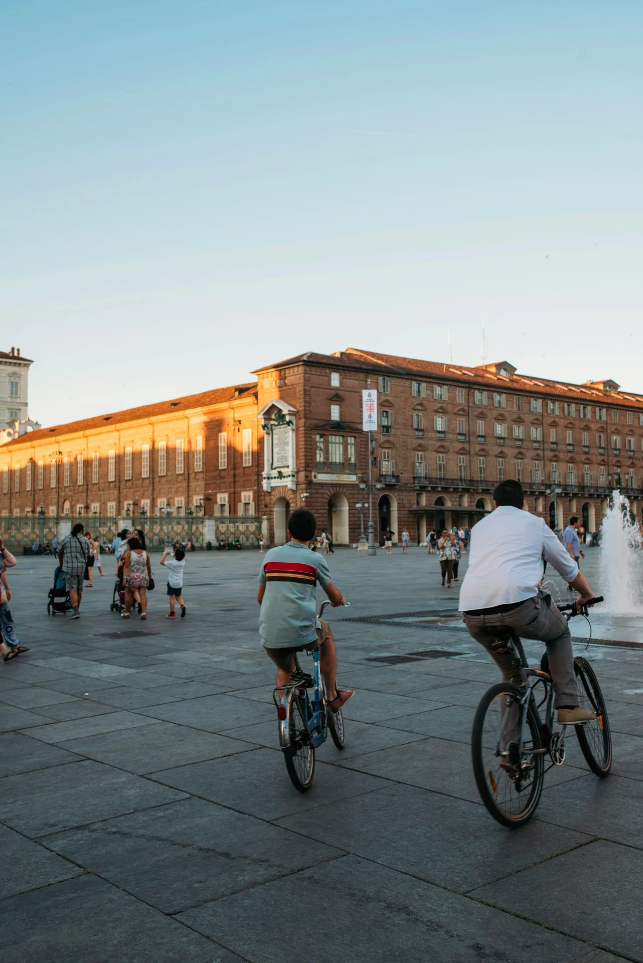 A group of people riding bicycles beside a fountain.